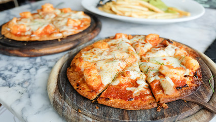 Tom Yum Kung pizza with shrimp on top in wooden plate