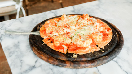 Tom Yum Kung pizza with shrimp on top in wooden plate