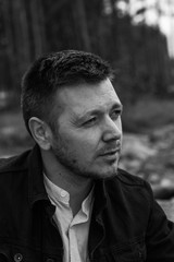 Handsome young man portrait. Intense look and eye-catching beauty. Fashionable hair and beard. The young man is wearing a white shirt.