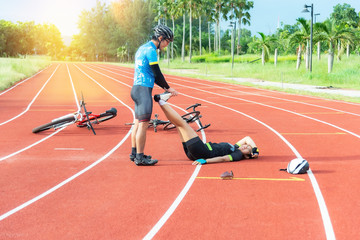 Male cyclists first aid woman cyclists cramp on track in concept team, together and sport.Cyclist Concept