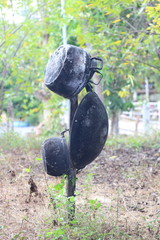 Old pot and pan hung on wooden post.