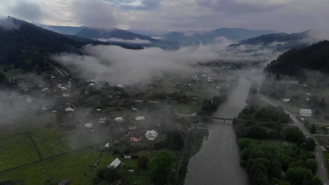 Aerial view: Misty forest and village, Flying through the clouds, Carpathians , Ukraine.4k