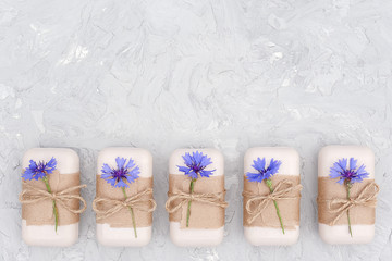 Handmade natural soap set decorated with craft paper, scourge and blue flowers. Organic cosmetics concept. Top view Flat lay Copy space Template for design