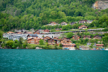 Fototapeta na wymiar Beautiful scene of village beside the lake Brienz on fresh green forest background with copy space, Switzerland