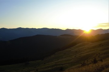 Naklejka na ściany i meble evening rays of the sun over the mountains
