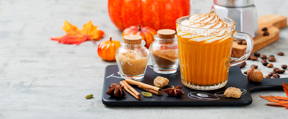 Pumpkin spice latte in a glass mug with cinnamon and nutmeg .