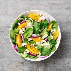 Fresh spinach salad with oranges, feta (ricotta) cheese, red onion and pine nuts .