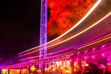 Helsinki, Finland - 19 October 2019: The Carnival of Light event at the Linnanmaki amusement park. Ride train Maisemajuna in motion. Night illumination, long exposure.