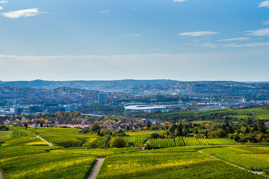Germany, View over skyline, roofs, houses vineyard and arena of city stuttgart from above in autumn season on sunny day