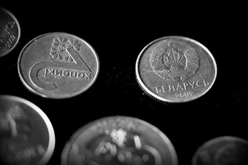 Belarusian coins scattered on a dark surface close up. Monochrome money background