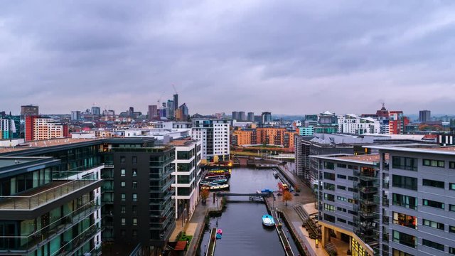 Leeds, UK. Aerial view of Leeds docks, England, UK during the sunset. Time-lapse of heavy clouds over the modern buildings, apartments in the evening and night, zoom in
