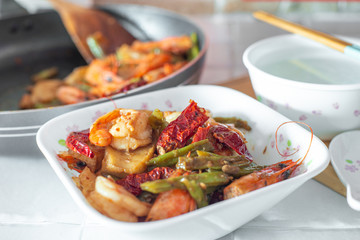 Stir-fried spicy dried chilli french green beans with prawns, and a bowl of porridge.