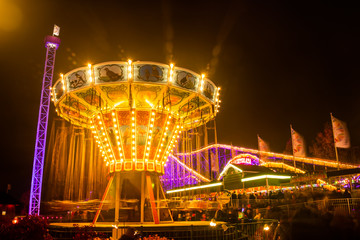 Helsinki, Finland - 19 October 2019: The Carnival of Light event at the Linnanmaki amusement park. Ride chain carousel Ketjukaruselli in night illumination.