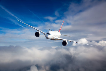 White passenger plane in flight. The plane flies against a background of a cloudy sky. Aircraft...