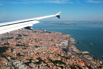 Visit Portugal! The historical center of Lisbon under the plane wing. Roofs of houses and old quarters.