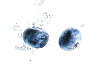 Obraz na płótnie Canvas Two organic Blueberry sinking into water with air bubbles white background. Macro detailed closeup.