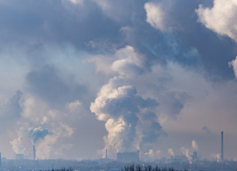 Naklejka na ściany i meble Smoke from the chimneys of a metallurgical plant at dawn
