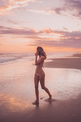 Fototapeta na wymiar girl on the beach at sunset looking away at the horizon