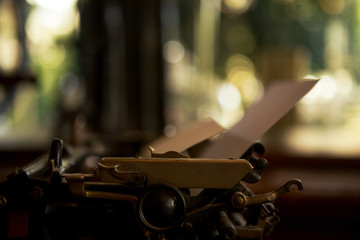 Selective focus on 19th century old black typewriter with blank paper ready for new text. Copy space.