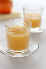 Two glasses of refreshing orange juice on a white table