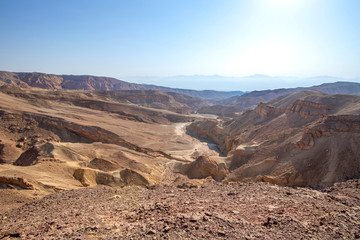 Fototapeta na wymiar View of the colorful mountains and valley of Eilat Red Canyon against the blue sky. Israel