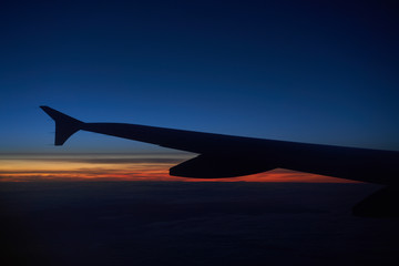 Fototapeta na wymiar Wing of an Airbus A319 aircraft on a sunset sky.