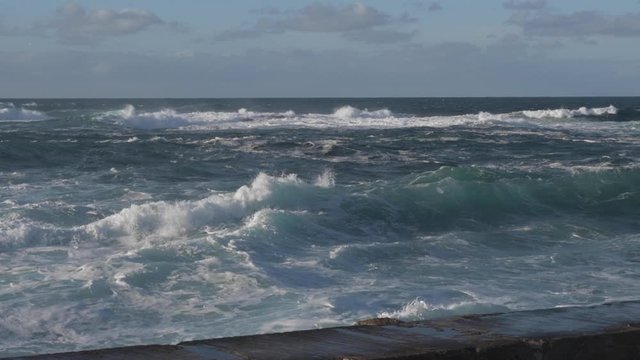 Slow motion waves crashing into each other creating spray