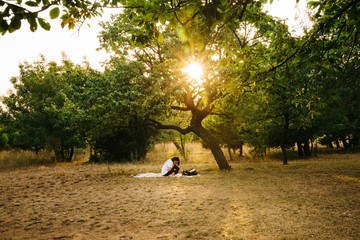 A female model is working/reading in a Public Park at sunset time