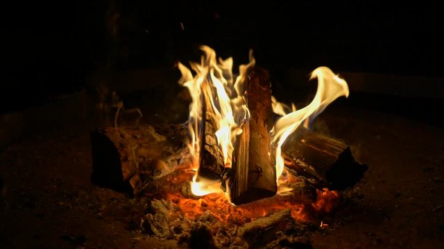 Flames of a campfire in the night. Fire burning in fireplace. Slow motion shot