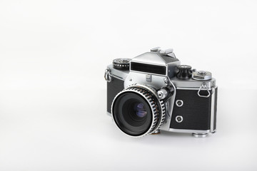 The old German 35 mm SLR film camera with lens 50 mm lens on a white background.
