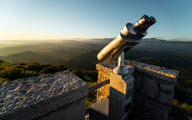 Paid spyglass at the observation deck. Tourist binocular tower coin operated machine. Telescope for sightseeing at a high point. Viewing the horizon from a height. - obrazy, fototapety, plakaty
