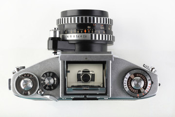The old German 35 mm SLR film camera with lens 50 mm lens on a white background. Shaft Viewfinder Camera.