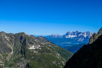 Massive mountain range of Schladming Alps, Austria. The slopes of Alps are steep, partially overgrown with green bushes. Dangerous mountain climbing.Clear and beautiful day. Endless mountain ranges,