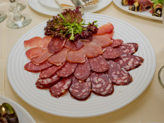 Different meat slices on a plate.