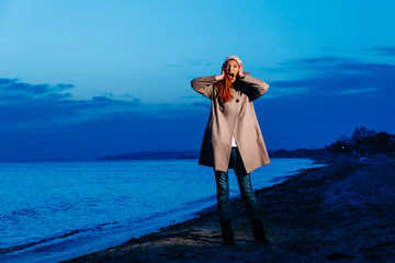 red hair female model with coat, after the sunset the sky is blue and female model enjoying the...