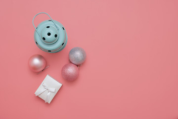 Top view of pink christmas balls and mint lamp on pink background. New year holidays. Copy space