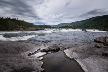 Otra river running wild with dark clouds above dramatic dark scene Norway