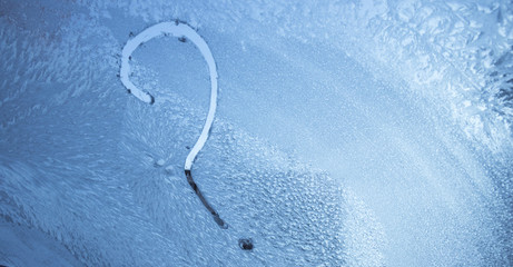 question mark on frozen glass in winter drawn by finger on ice