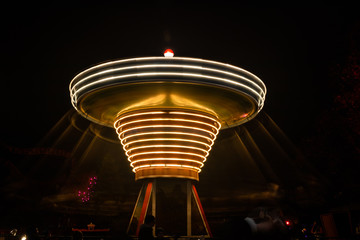 A blurry colorful carousel in motion at the amusement park, night illumination. Long exposure.