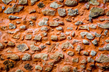 Eine alte Mauer mit abbröckelndem rotem Putz