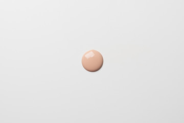 Gota de maquillaje liquido sobre fondo blanco