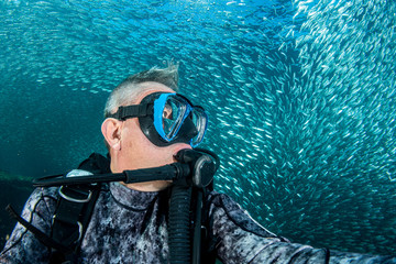 diver underwater selfie inside sardines bait ball