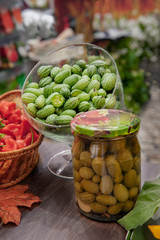 Canned fruit vegetable melotria in a glass jar. Fermented melothria on the table