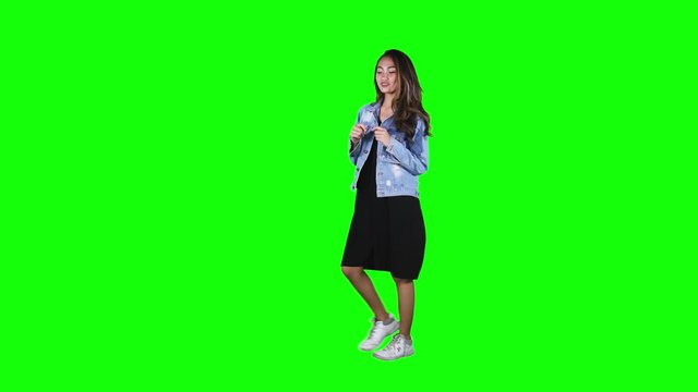 JAKARTA, Indonesia - November 08, 2019: Full length of pretty teenage girl dancing in the studio with green screen background. Shot in 4k resolution