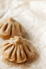 Buns of rye flour are on light paper. Homemade cake. Mexican day of dead bread, pan de Muerto