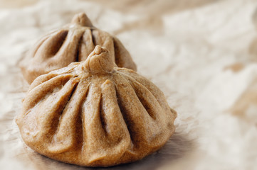 Buns of rye flour are on light paper. Homemade cake. Mexican day of dead bread, pan de Muerto