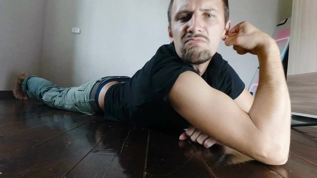 A funny ugly slim man, showing his muscles by flexing them