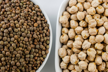 Lentils and chickpeas. Mediterranean legumes in two bowls in the foreground aerial shot.