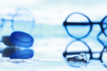 Tools for vision correction. Glasses and lenses with diopters on the background of splashes and...