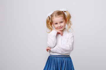 little girl in school uniform  on a white background smile